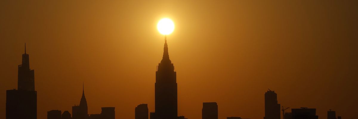 Sun rises behind Manhattan skyline